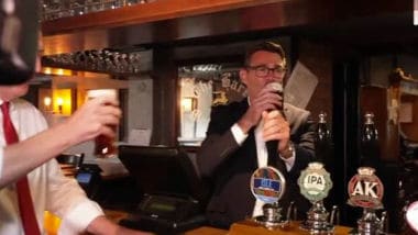 Andy Burnham festeggia il taglio delle tasse al pub con birra in mano